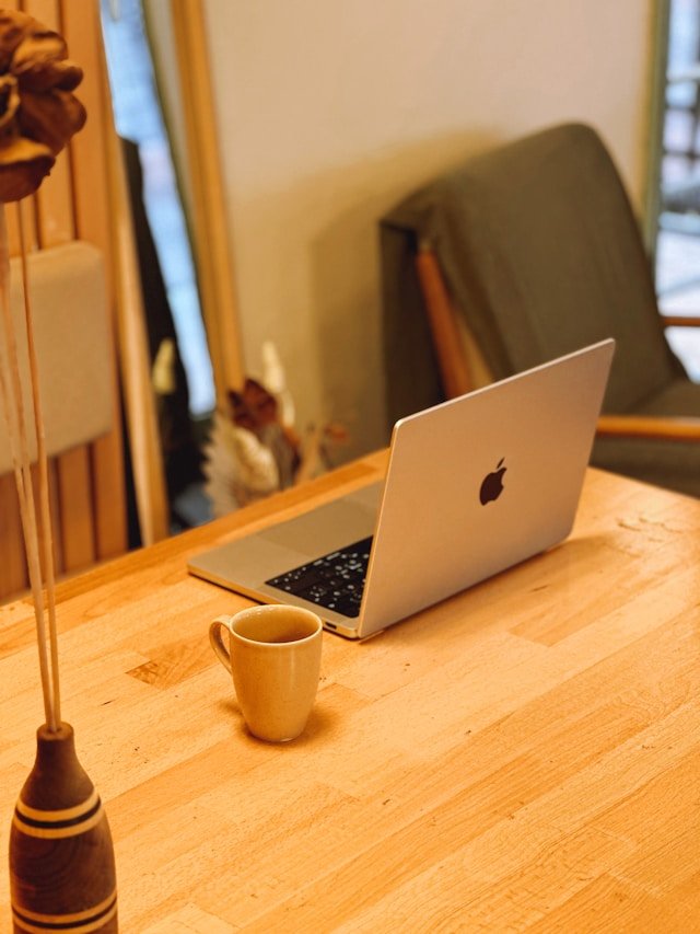 umutcan-eyriyer-6LgnNx5p4aQ-unsplash Minimal workspace setup with a laptop and coffee cup on a wooden desk, creating a calm and productive work environment